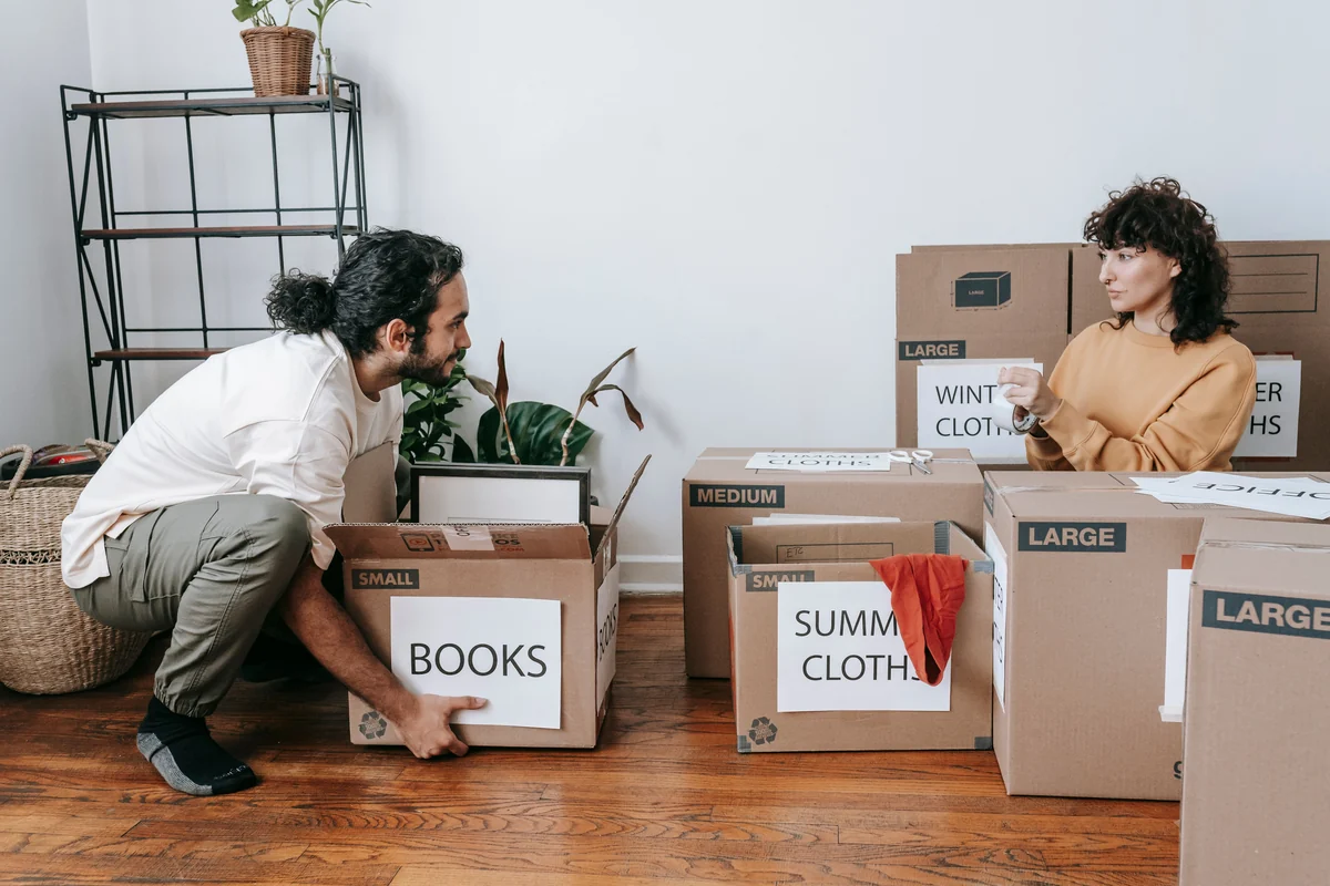 Household boxes, photographs and belongings being sorted during a residential downsizing and moving-preparation project